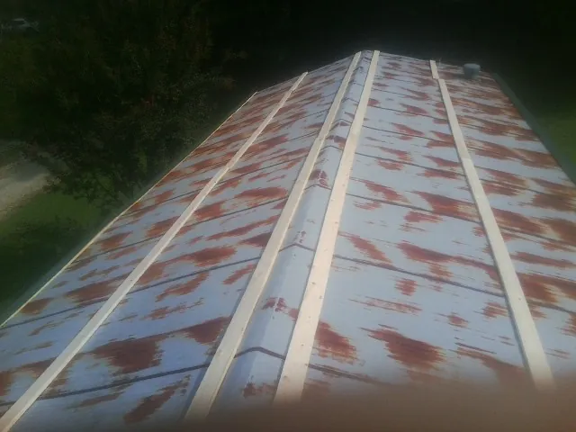 Rusted metal roof panels with new wood purlins before replacement — Storm Damage Roof Repair in Center by Roofing Brothers