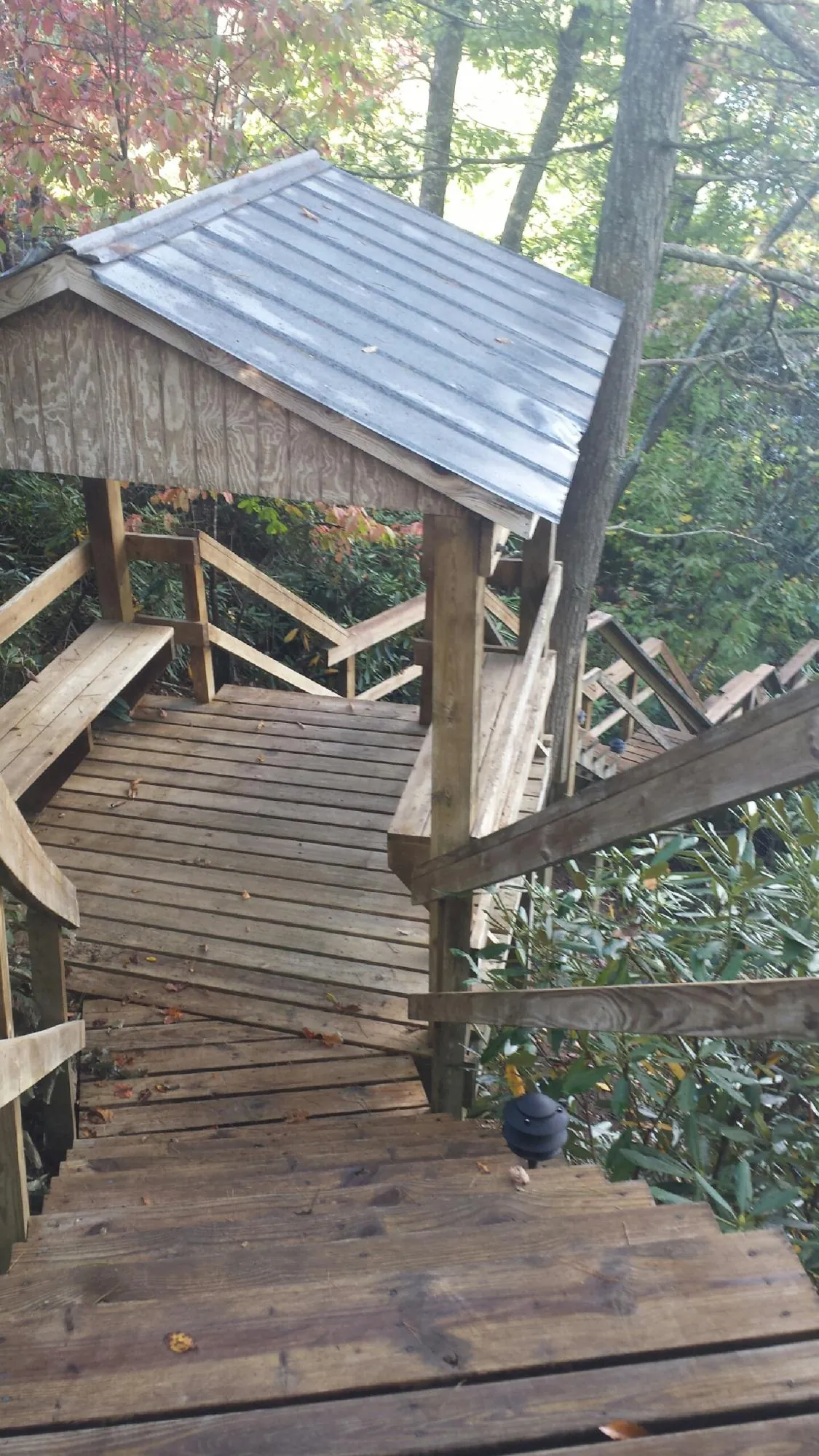 Metal roofed shelter over wooden steps on a wooded walkway — Skylight Repair & Installation work by our crew in Center