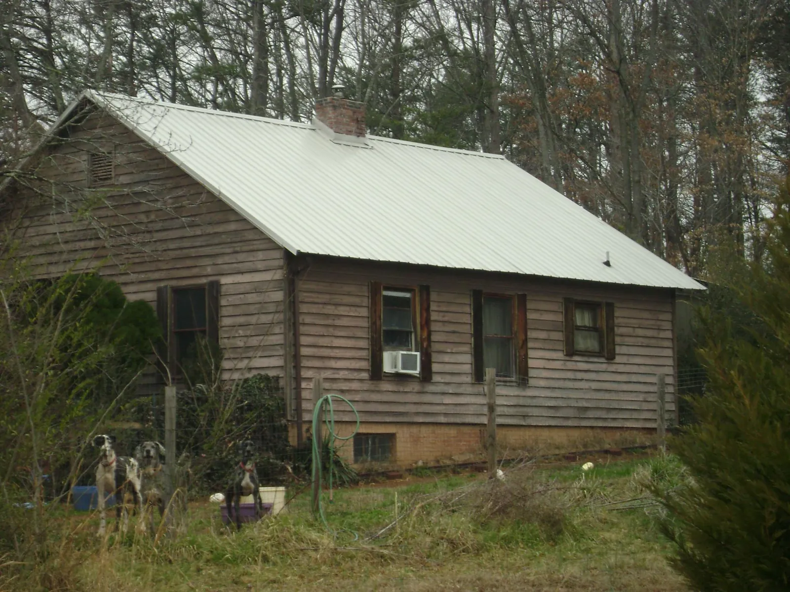 White metal roof on an old wood sided farmhouse, from a Metal Roof Installation job in Center